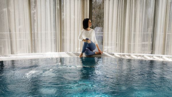 Yogalehrerin in Yoga-Pose am Thermalpool